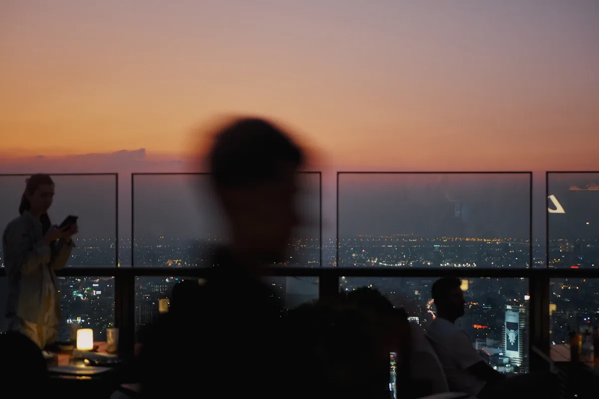 A rooftop bar with the city behind it at golden hour